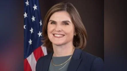 A woman in front of an american flag.