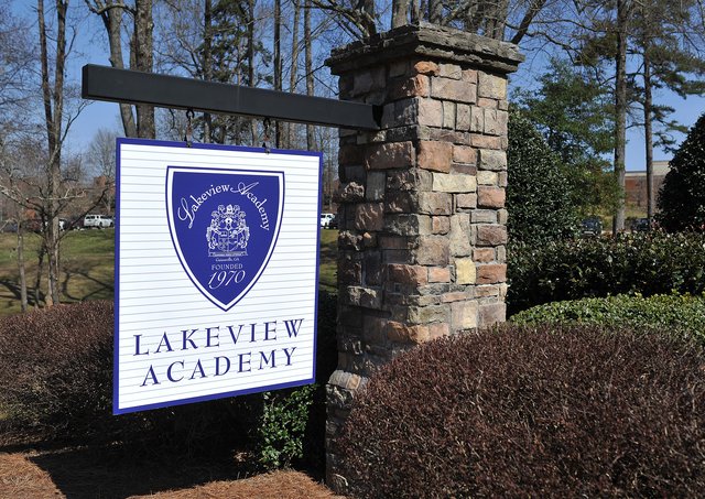 A sign for lakeview academy in front of a brick wall.