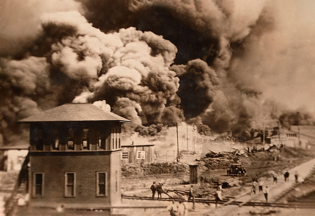 A black and white photo of a fire in the background.