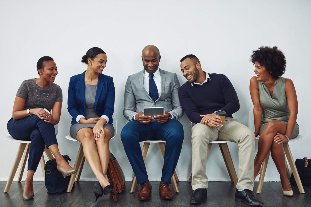 A group of people sitting in chairs looking at something on the screen.