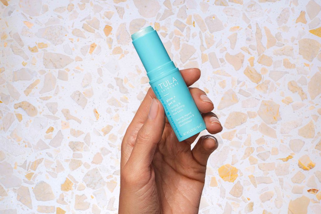 A person holding an empty lip balm tube.