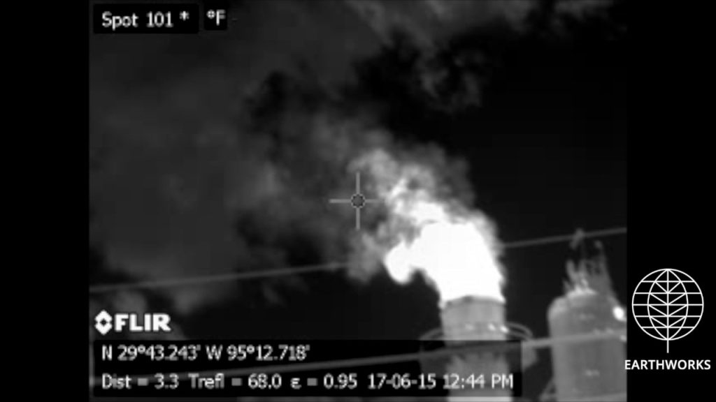 A black and white photo of smoke coming from a factory.