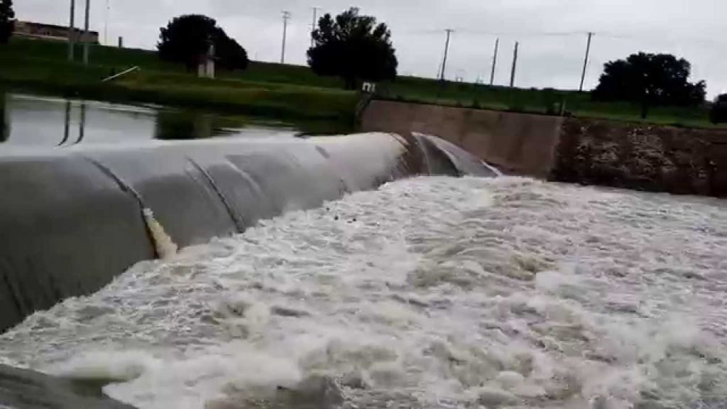 A large water pipe with white foam coming out of it.