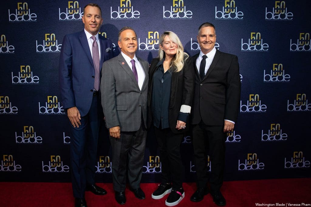 A group of people standing on the red carpet.