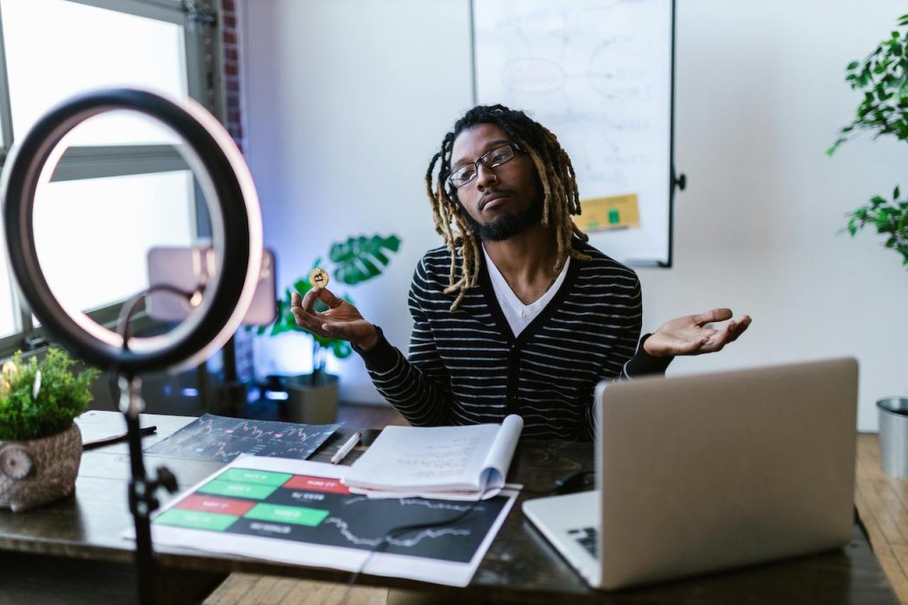 A man sitting at a desk with his hands in the air.