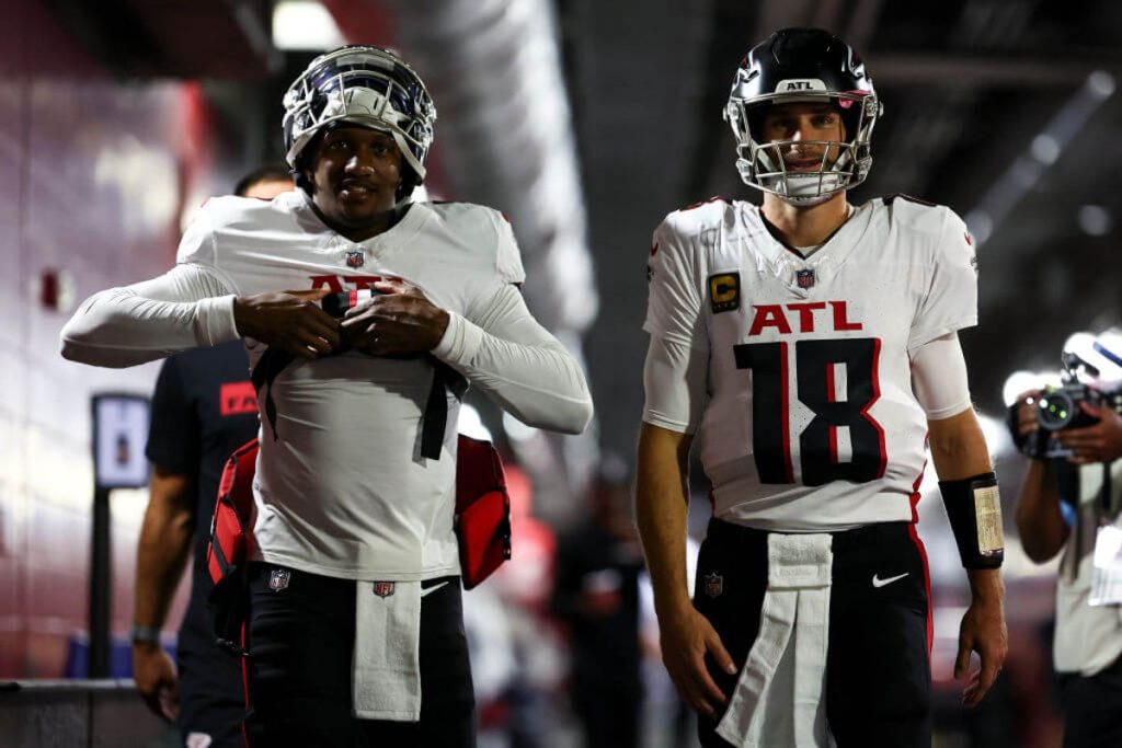 Two atlanta falcons players are walking on the field.