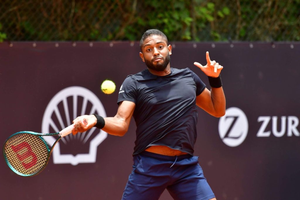 A man swinging at a tennis ball with his racket.