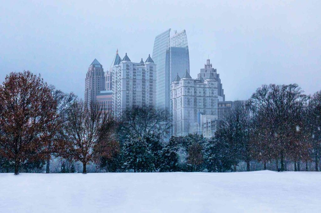 A snowy day in the city with tall buildings.