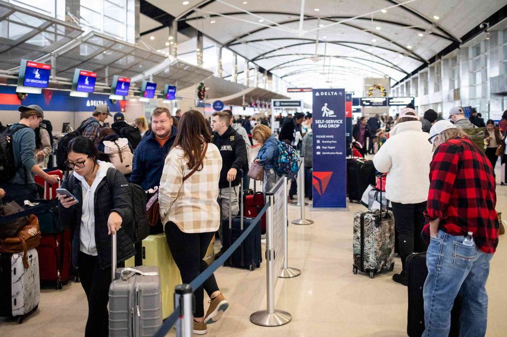 A crowd of people standing around in an airport.