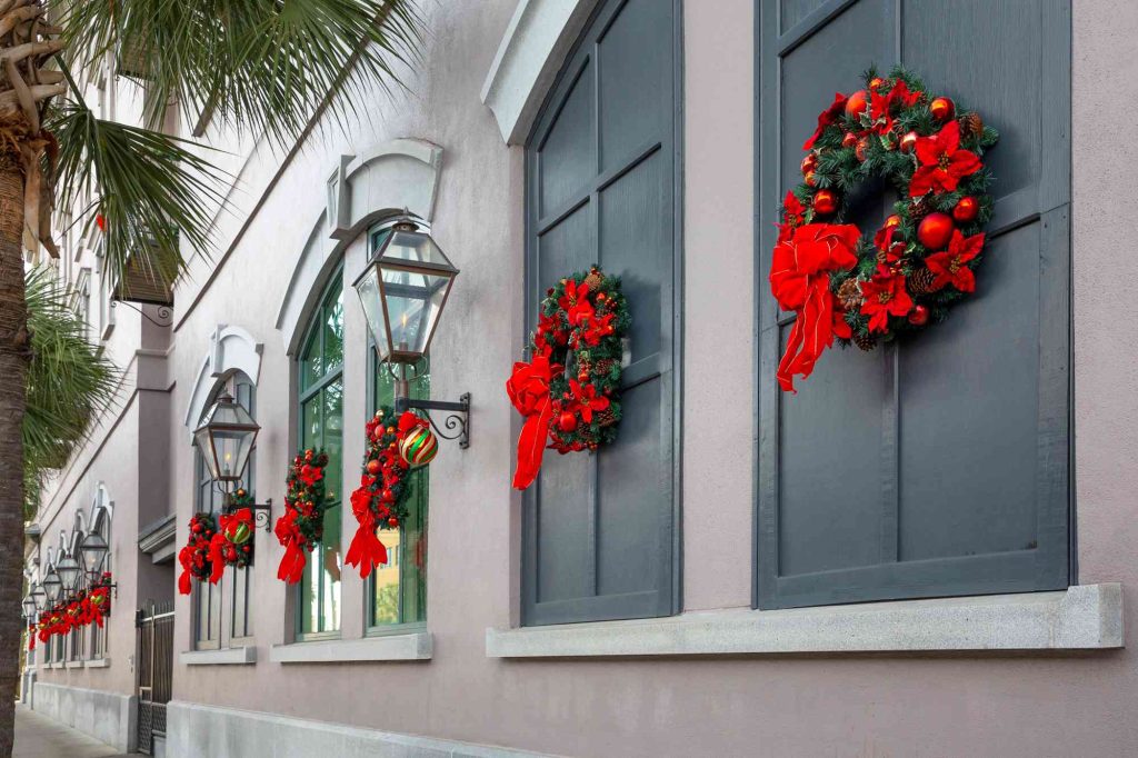 A row of windows with christmas wreaths on them.