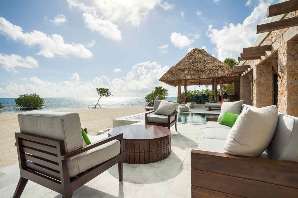 A patio with chairs and tables on the beach