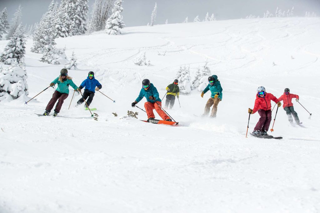 A group of people skiing down the side of a mountain.