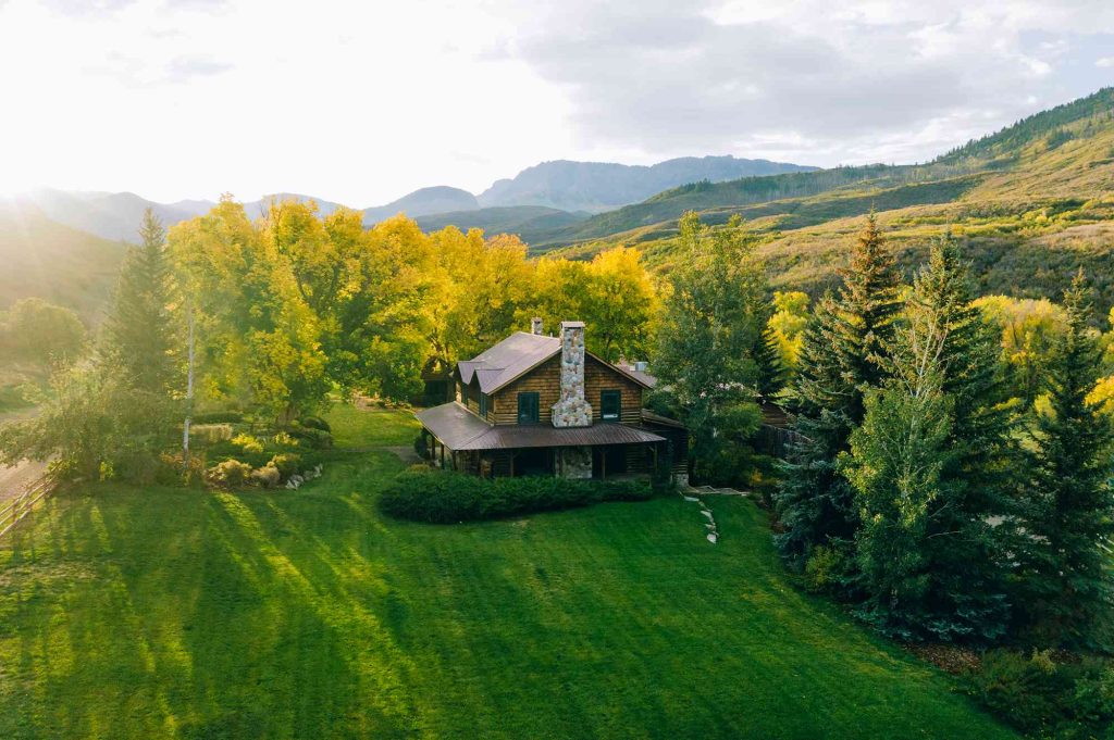 A house sitting on top of a green hillside.