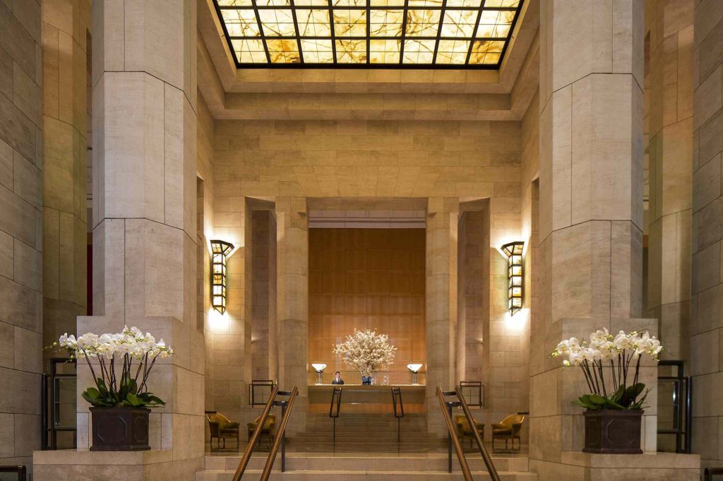 A lobby with tables and chairs, two windows, and a skylight.