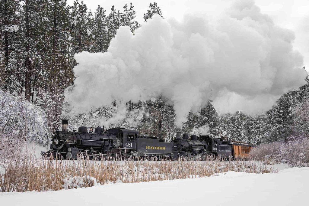 A train is coming down the tracks in winter.