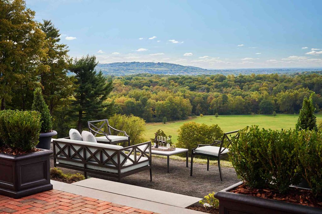 A patio with furniture and trees in the background.