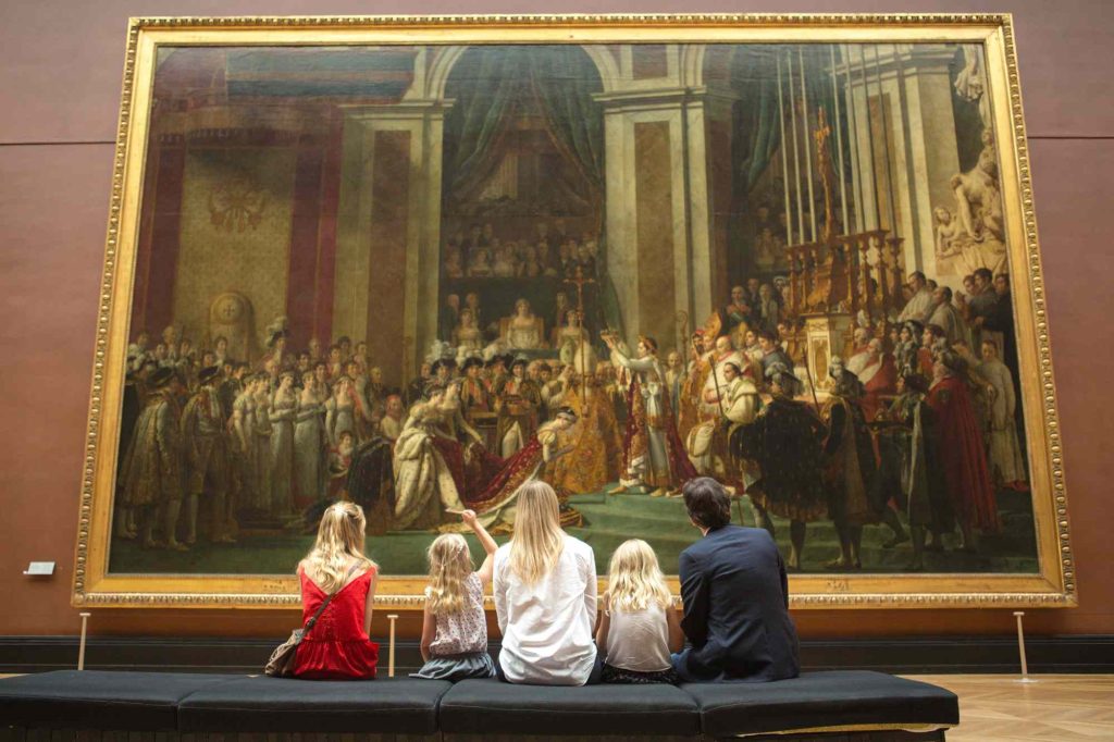 A group of people sitting on top of a wall.