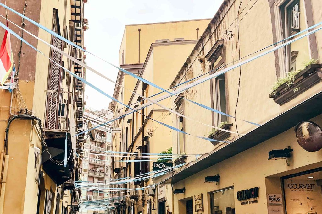 A street with many wires hanging from the side of it.