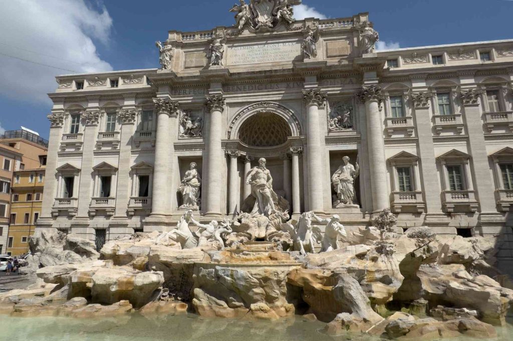 A large fountain with statues in front of it.