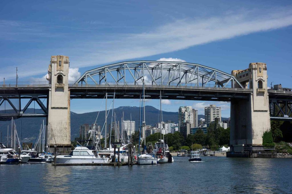 A bridge over water with boats in it.