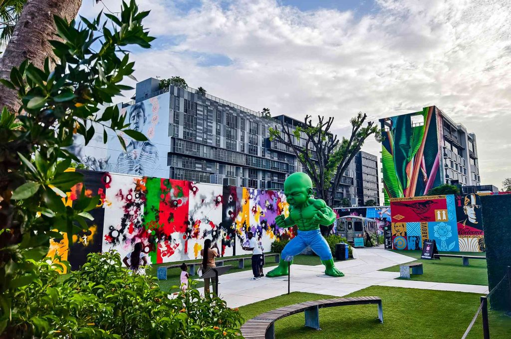 A green man is standing in the grass.