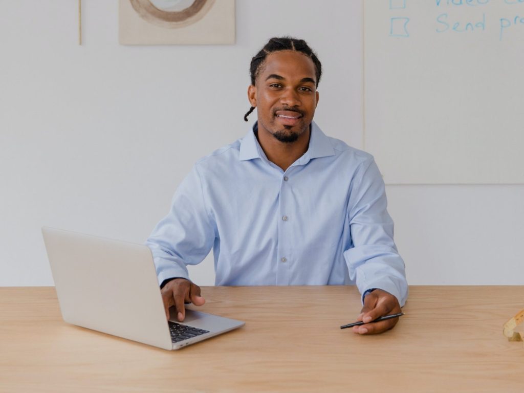 A man sitting at a table with a laptop.