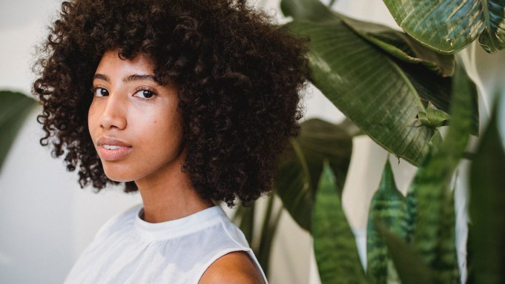 A woman with curly hair is posing for the camera.