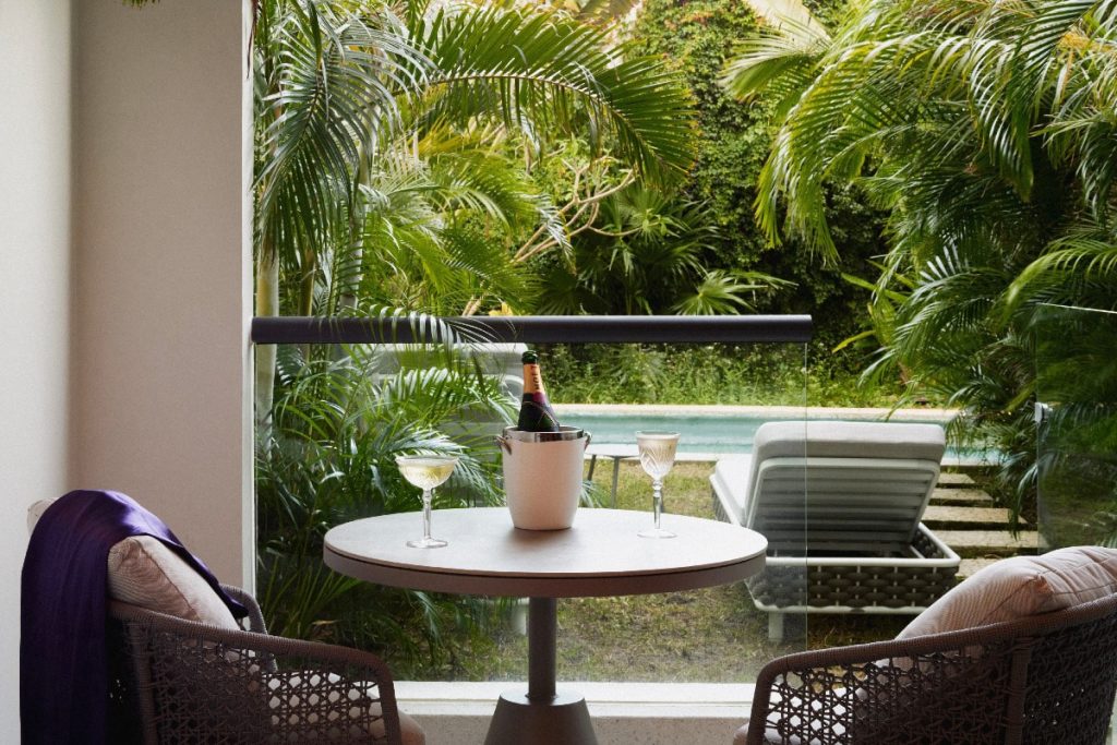 A table with two chairs and a bottle of wine on it