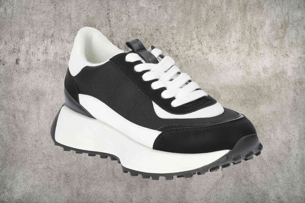 A pair of black and white sneakers on top of each other.