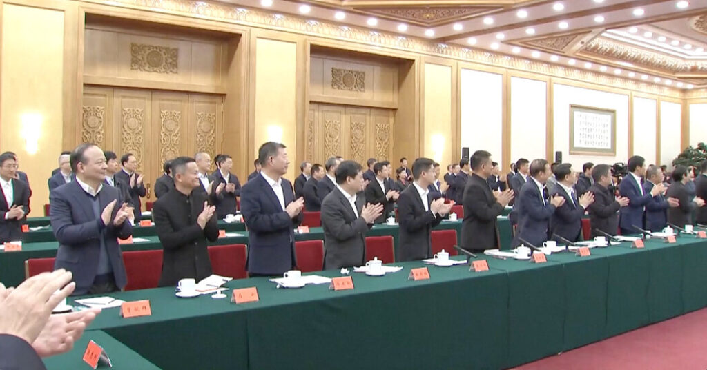 A group of people standing in front of tables.