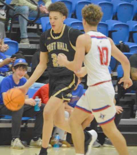 A couple of men playing basketball on a court.