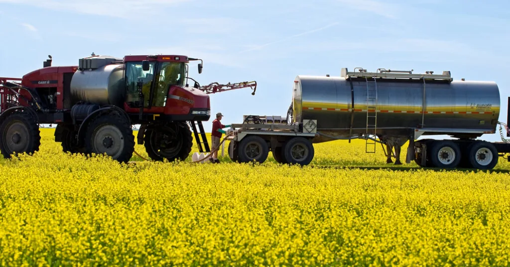 A tractor pulling a trailer in the middle of a field.