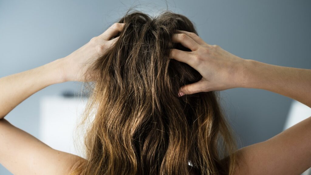 A woman with her hands on top of her head.