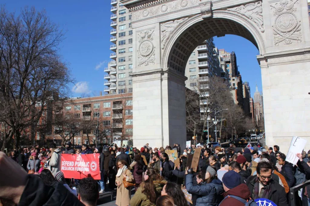 A large crowd of people gathered under the arch.