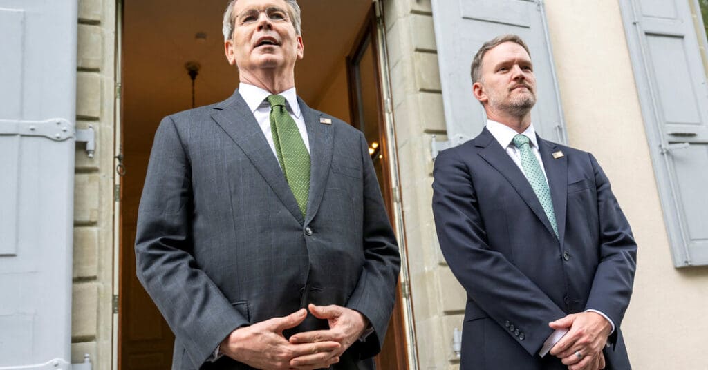 Two men standing outside a building entrance.