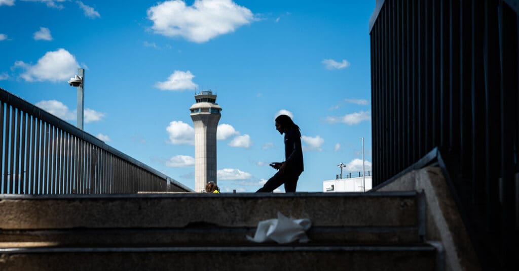 Silhouette of person near airport control tower.