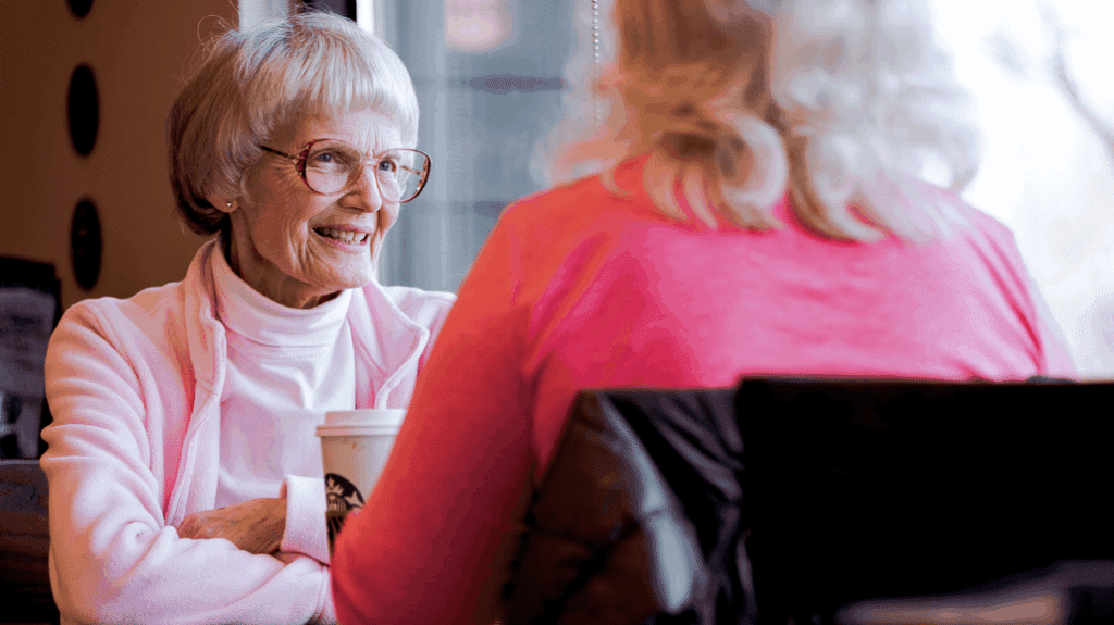 2 senior women talking at a coffee shop