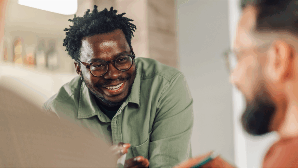 Smiling man in glasses during conversation.