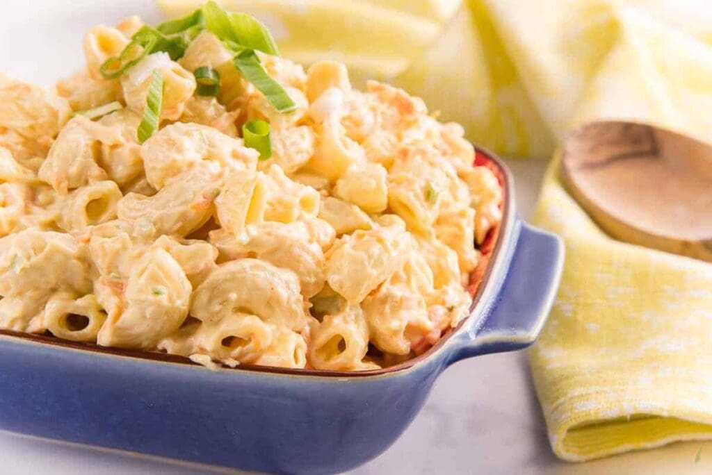 Creamy macaroni salad in blue dish.