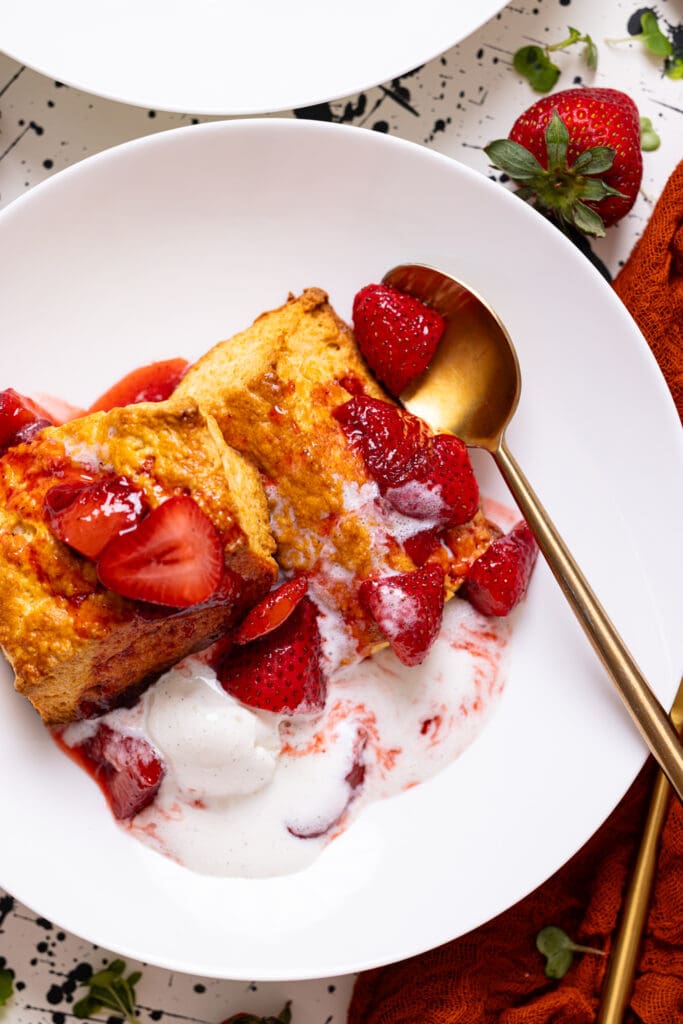 Up close shot of My Fave Strawberry Shortcake Biscuits on a white plate with a spoon.