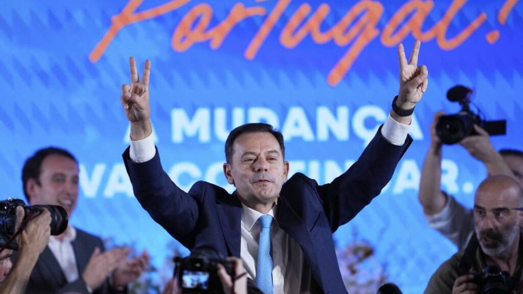 Man celebrating with peace signs on stage.