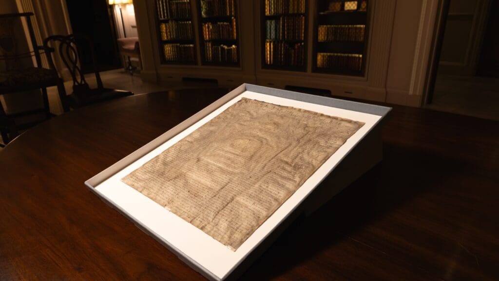 Ancient manuscript displayed on wooden table.