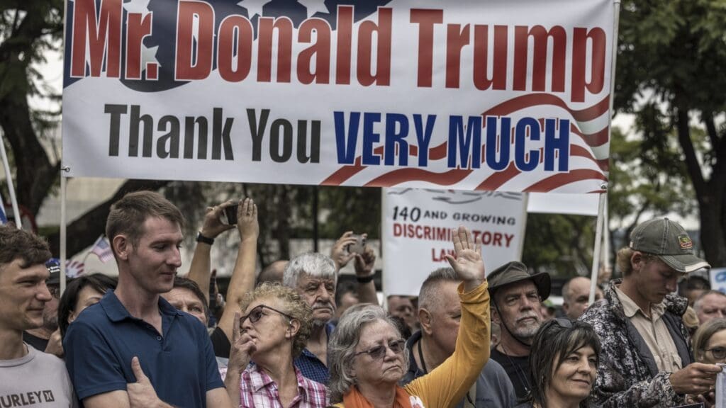 Afrikaners evacuees standing as a result of get here in united state on Monday: NPR Crowd holding "Thank You, Donald Trump" sign.