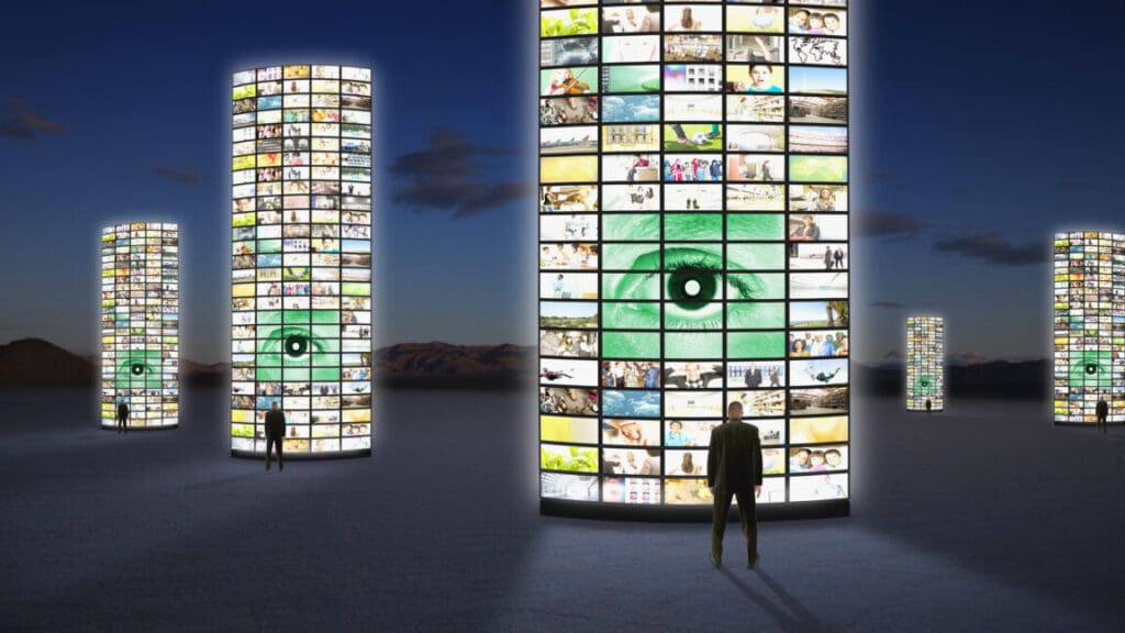 Businessmen standing next to pillars of television screens