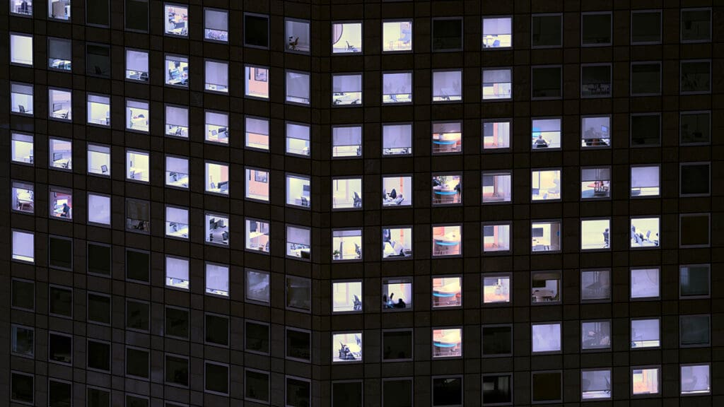 Office building windows illuminated at night.