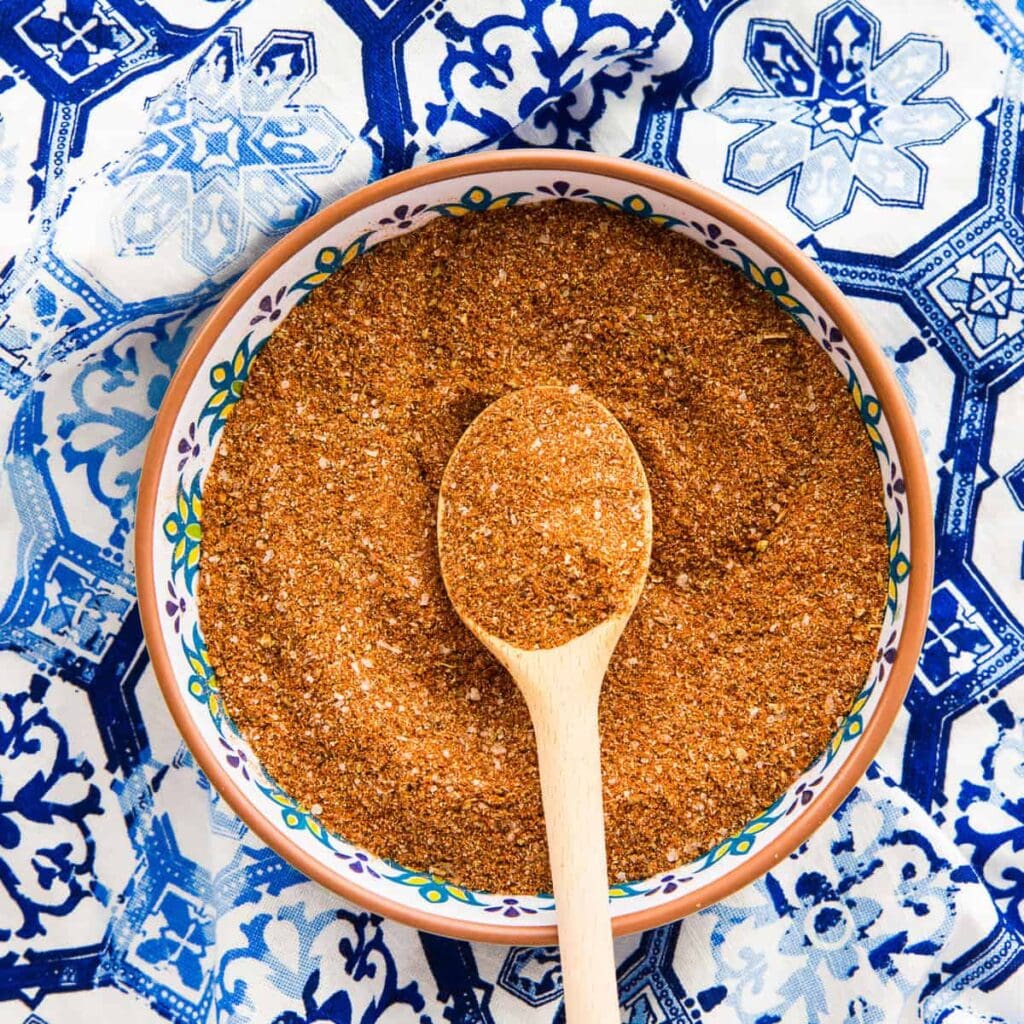Spice blend in decorative bowl with spoon.