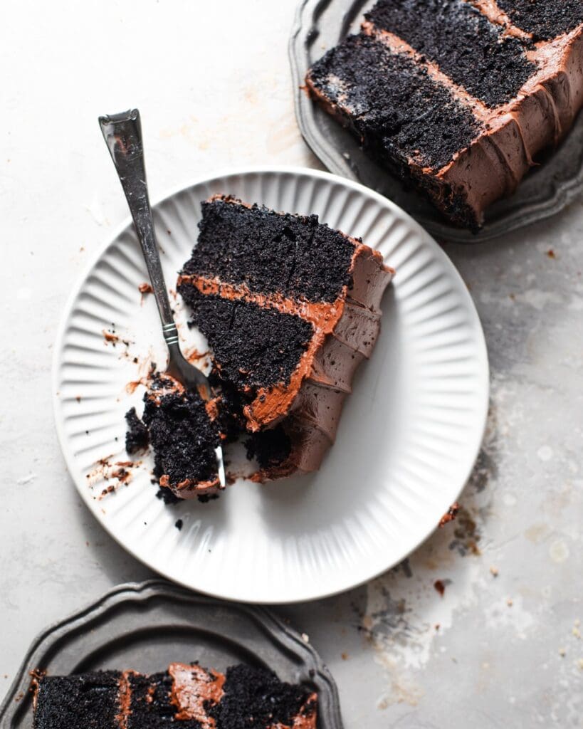 Chocolate cake slices on white and grey plates.