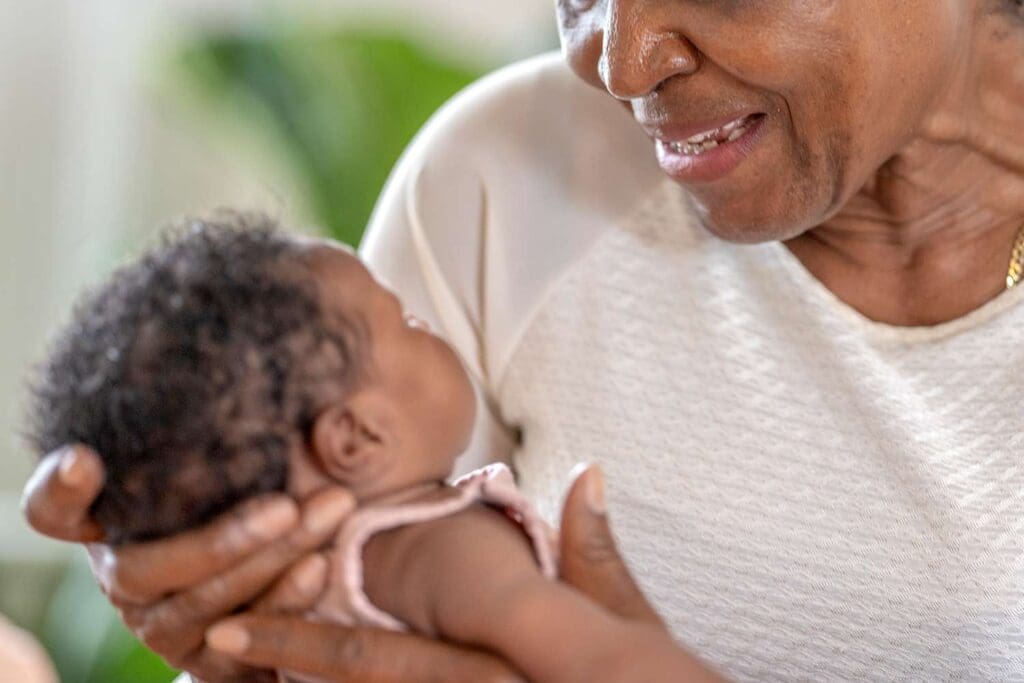 Stock image of older woman holding baby