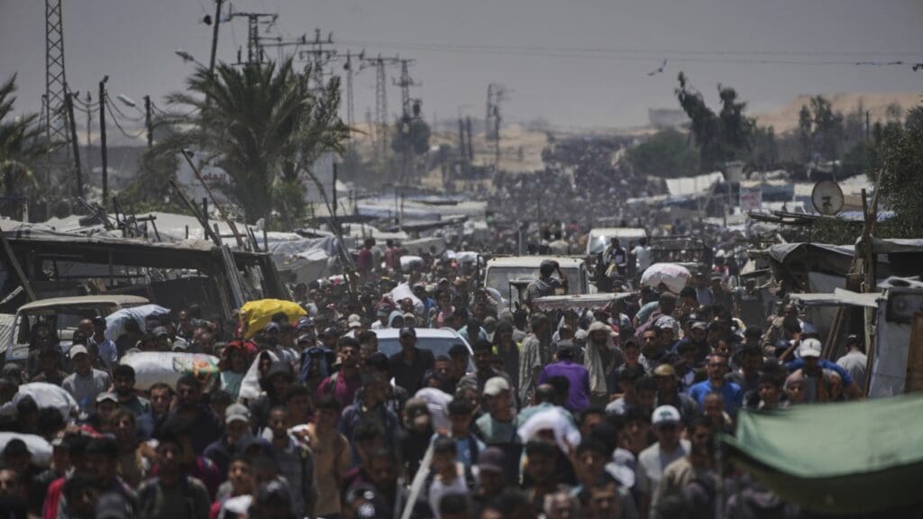 Palestinians claim at the very least 5 individuals eliminated by Israeli shooting near Gaza help facilities: NPR Crowded street with many people walking.
