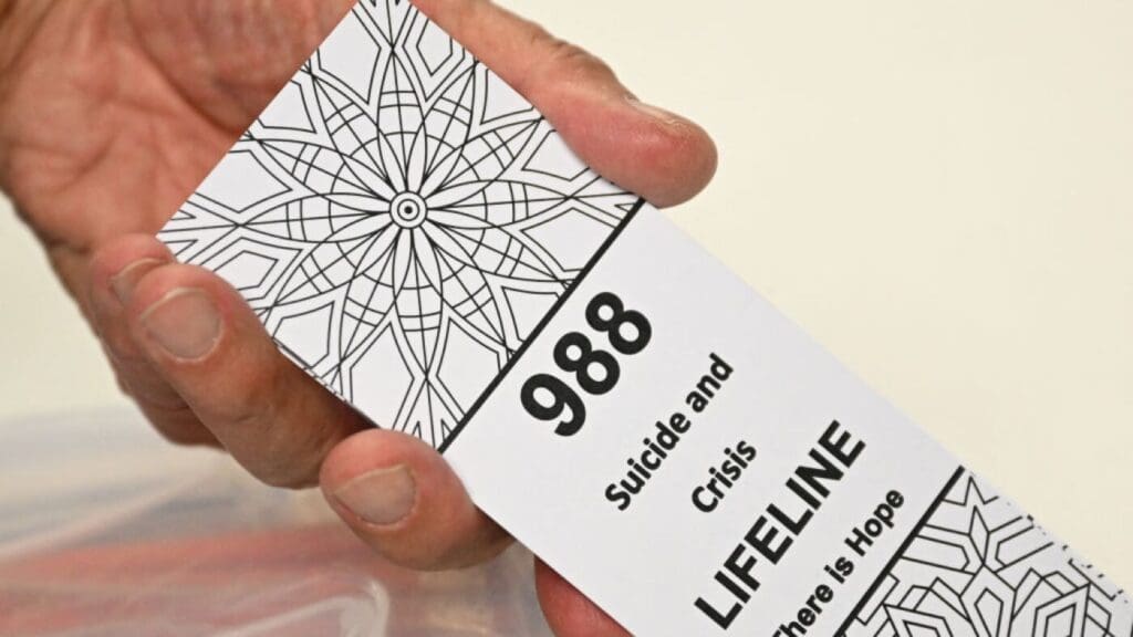 Hand holding 988 crisis lifeline information card.